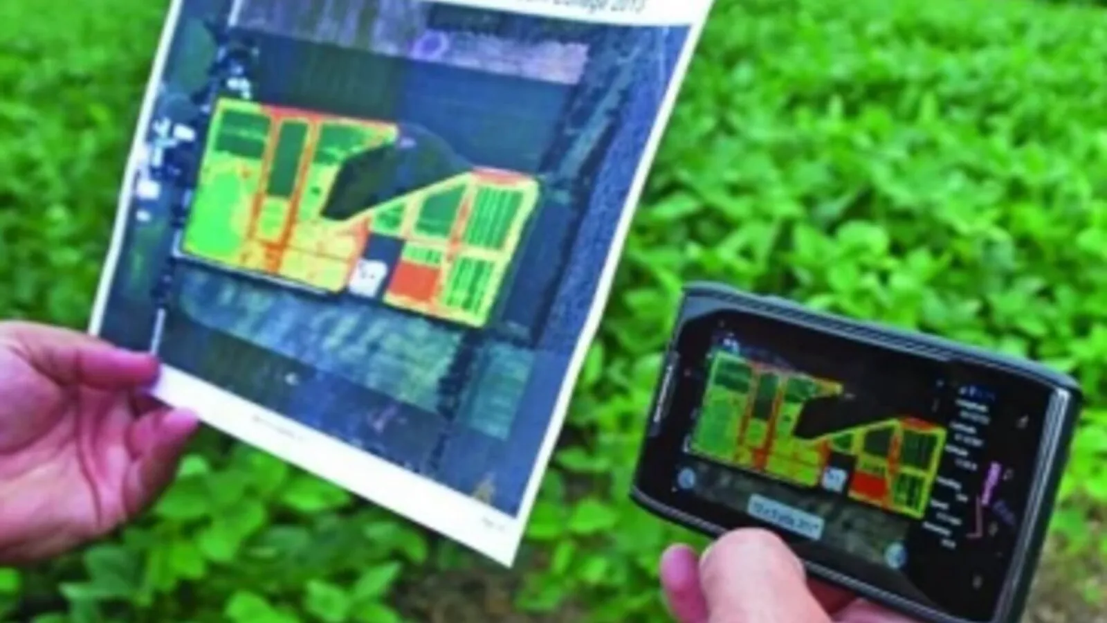 Agricultor sosteniendo un mapa de prescripción agronómico impreso junto a un teléfono móvil mostrando el mismo mapa por zonas de manejo